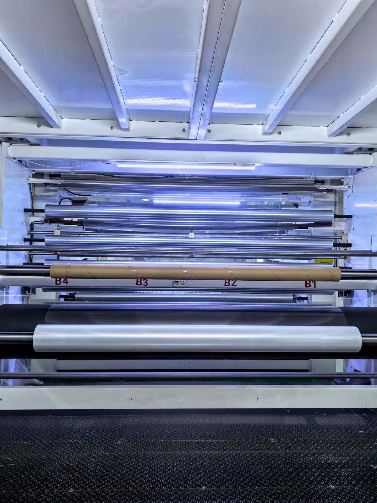 Finished film running through the roller stack of a rewind station